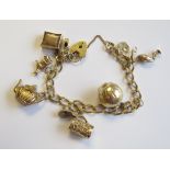 A 9ct gold curb link Bracelet with padlock fastener and numerous charms, approx 39gms all in