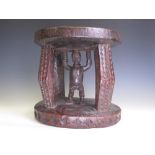 A Congo Stool, possibly Lega, the four bowed legs with chip carved faces, the central support as a