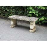 A composition Garden Bench with rectangular seat on shaped supports, 3ft 11in W