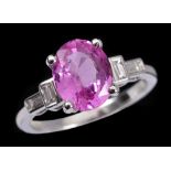 A Pink Sapphire and Diamond Ring claw-set oval-cut sapphire, 2.44cts, between two pairs of diamond