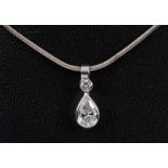 A Diamond Drop Pendant rubover-set brilliant-cut stone above pear-cut stone on spirotube chain in