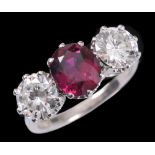 A Ruby and Diamond three stone Ring claw-set oval-cut ruby, calculates as 2.27cts, between two