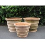 Three large terracotta Garden Planters of ribbed tapering design; two 2ft 3in diam x 1ft 8in H and