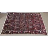 A Persian style Rug of bordered design with stylised motifs on a brown ground, 8ft 7in x 5ft 11in