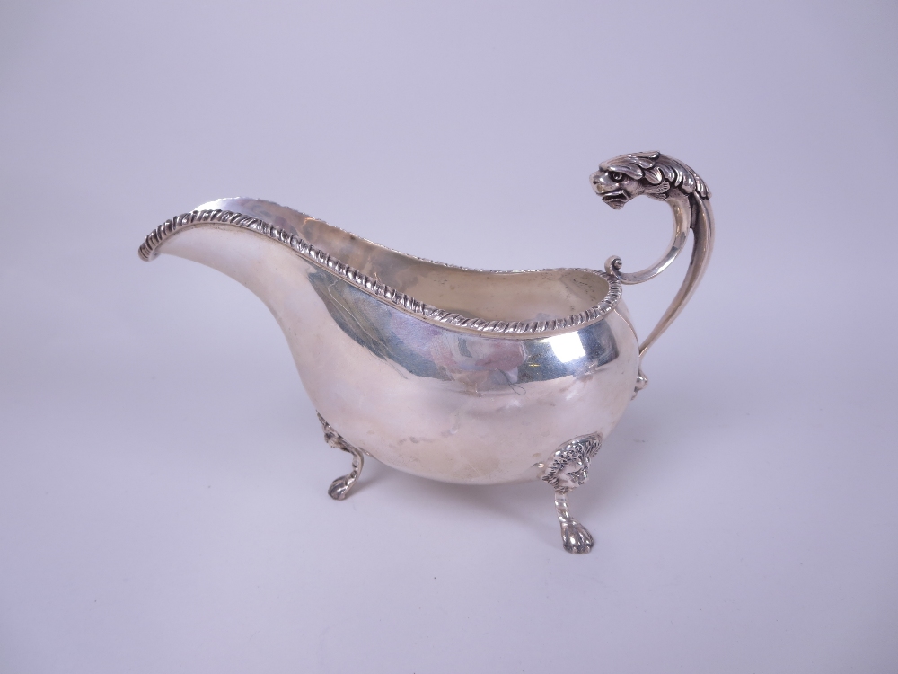 A George V silver Sauce Boat with gadroon rim, mask and leafage scroll handle on lion mask and paw