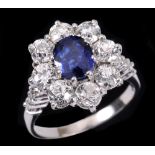 A Sapphire and Diamond Cluster Ring claw-set oval-cut sapphire within a frame of eight old-cut