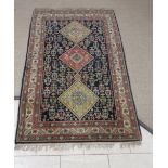 A Persian style bordered Rug with design of three central lozenges on a blue ground, 6ft 10in x