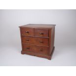 A 19th Century walnut miniature Chest of two short and two long drawers on bracket supports