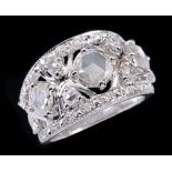 A Diamond Ring having pierced band claw-set three principle rose-cut stones between pavé-set