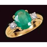 An Emerald and Diamond three stone Ring claw-set oval-cut emerald btween two brilliant-cut