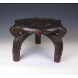 A HeHe Stool, Tanzania, circular seat with perimeter lugs above three bowed legs, 12in. H