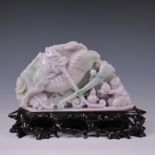 A Chinese jadeite or hardstone Carving of a Qilin, with long forked tongue, standing on a base