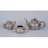 A Chinese silver three piece Tea Service decorated insects and chrysanthemum, the teapot and sucrier