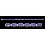 A Tanzanite and Diamond Line Bracelet claw-set twenty oval-cut tanzanite, total weight 11.60cts,