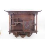 A Japanese hardwood Wall Cabinet with a pierced frieze above an arrangement of shelves and a