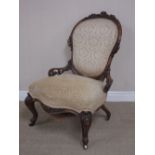 A Victorian walnut Occasional Chair with floral carving to the back and low arms on carved