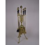 An ebony and brass Companion Set in the manner of Dresser, the stand with pierced and scrolled