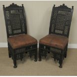 A pair of Egyptian ebonised mashrabiyya Side Chairs, c. 1900, carved cresting rails, above lattice