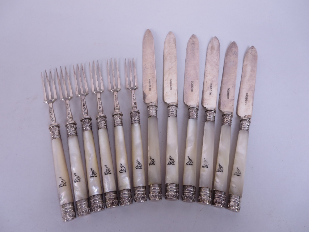 Six Victorian Dessert Knives and Forks with silver mounts and blades, the mother of pearl hafts with