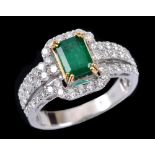 An Emerald and Diamond Ring corner claw-set step-cut emerald, 0.90cts, within halo frame of pavé-set