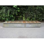 A long galvanised Feeding Trough with dividing bars, 6ft 3in long