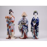 Three Japanese Kutani female Figures, Meiji Period, one holding a bowl, another with a hagoita, a