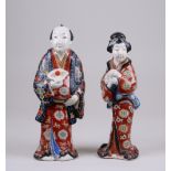 A pair of Japanese Kutani figures, Meiji Period, of a Samurai and his Wife, he holding fan, she a