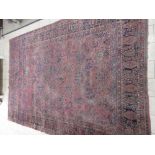 A large antique Sarouk Carpet, multi-bordered with floral motifs on a red ground, 15ft 7in x 10ft