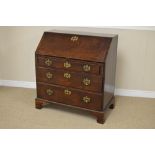 A Georgian mahogany Bureau, with fall flap enclosing arrangement of pigeon holes and drawers, fitted