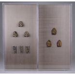 A collection of fourteen small Thai gilded terracotta votive Plaques, mounted in four perspex box