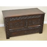 A 17th Century oak Mule Chest with plank lid above carved frieze and pair of rosette and tulip