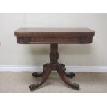 A William IV mahogany Tea Table with fold-over top on turned and reeded column and quadruple base