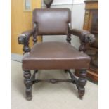 A Victorian Gothic Revival carved oak Armchair with cushioned brown leather back, seat and arm