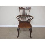 A 19th Century Windsor Elbow Chair with shaped top rail, stick back and solid seat on cabriole front