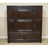 A 17th Century oak Hall Cupboard with lunette carved frieze above four panel door enclosing wooden
