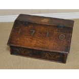 An antique oak table top Desk with hinged lid having ironwork strap hinges enclosing three small