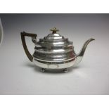 A George III silver Teapot of boat shape with leafage engraved frieze and vacant cartouches on