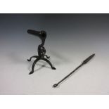A Goffering Iron on wrought iron stand with scroll decoration and quadruple base with pointed feet