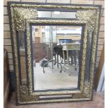 A 19th Century ebonised Wall Mirror with brass embossed floral decoration and bevelled plate, 3ft