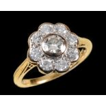 A Diamond Cluster Ring rubover-set brilliant-cut stone within a frame of eight smaller stones in