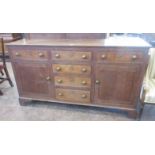 An antique oak Anglesey Dresser Base fitted six drawers and two doors on bracket supports, 5ft 6in