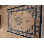 A Chinese Carpet with blue border, stylised floral motifs on a cream ground, 12ft 4in x 8ft 5in
