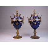 A fine pair of Sevres-style gilt bronze mounted porcelain Urns, late 19th Century, the mazarine blue