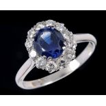 A Sapphire and Diamond Cluster Ring claw-set oval-cut sapphire within twelve brilliant-cut