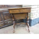 A Victorian figured walnut Sewing Table fitted with compartmentalised frieze drawer above sliding