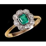 An Emerald and Diamond Cluster Ring rubover-set step-cut emerald within a frame of eight