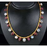 A Moonstone and Ruby Necklace claw-set eleven moonstone cabochons interspersed with trios of round