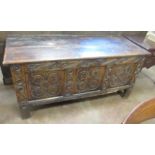 A 17th Century oak Coffer with plank lid above three rosette carved panels, 4ft 9in