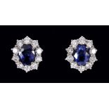 A pair of Sapphire and Diamond Cluster Earrings each claw-set oval-cut sapphire, estimated 1.