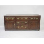 An 18th Century oak Dresser Base, triple plank top above an arrangement of five drawers and two